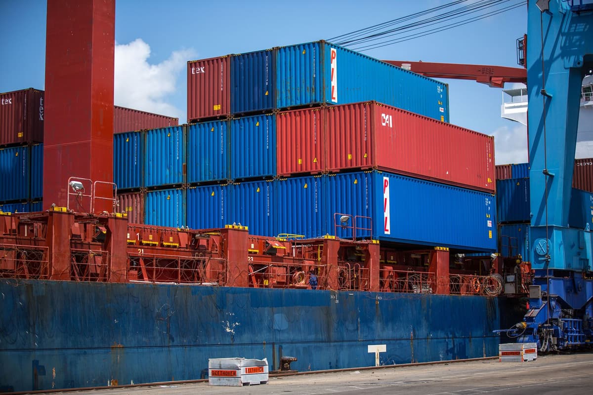 Stacked blue and red 40ft shipping containers on a ship alongside the quay at the Port of Mombasa