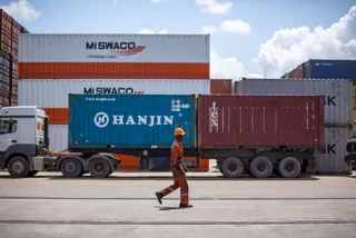 A prime mover hauling a 40ft container past stacked containers at the Port of Mombasa